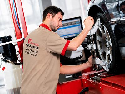 Mecânico alinhando veículo em equipamento de alinhamento